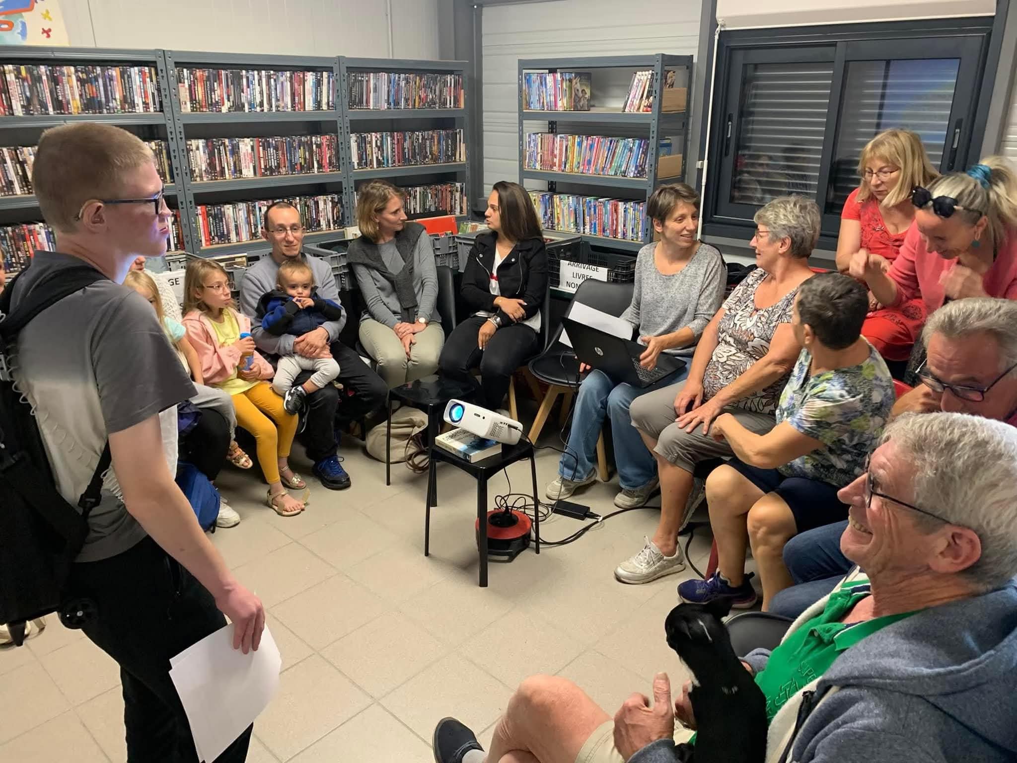 Bénévoles et familles réunis dans l'espace de tri des livres de l'association